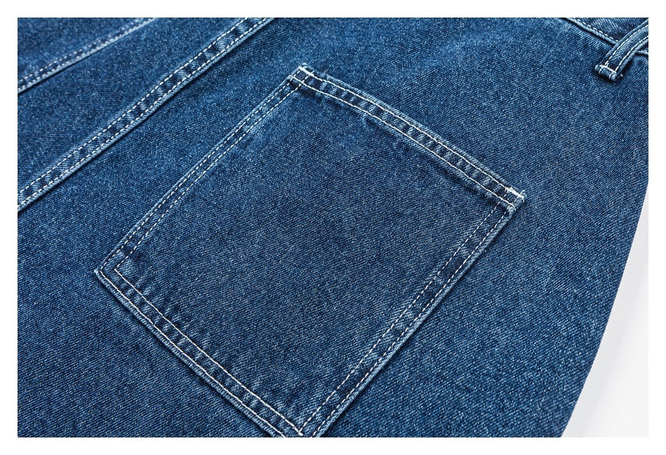 Close-up of a back pocket on dark blue jeans with contrasting double stitching.