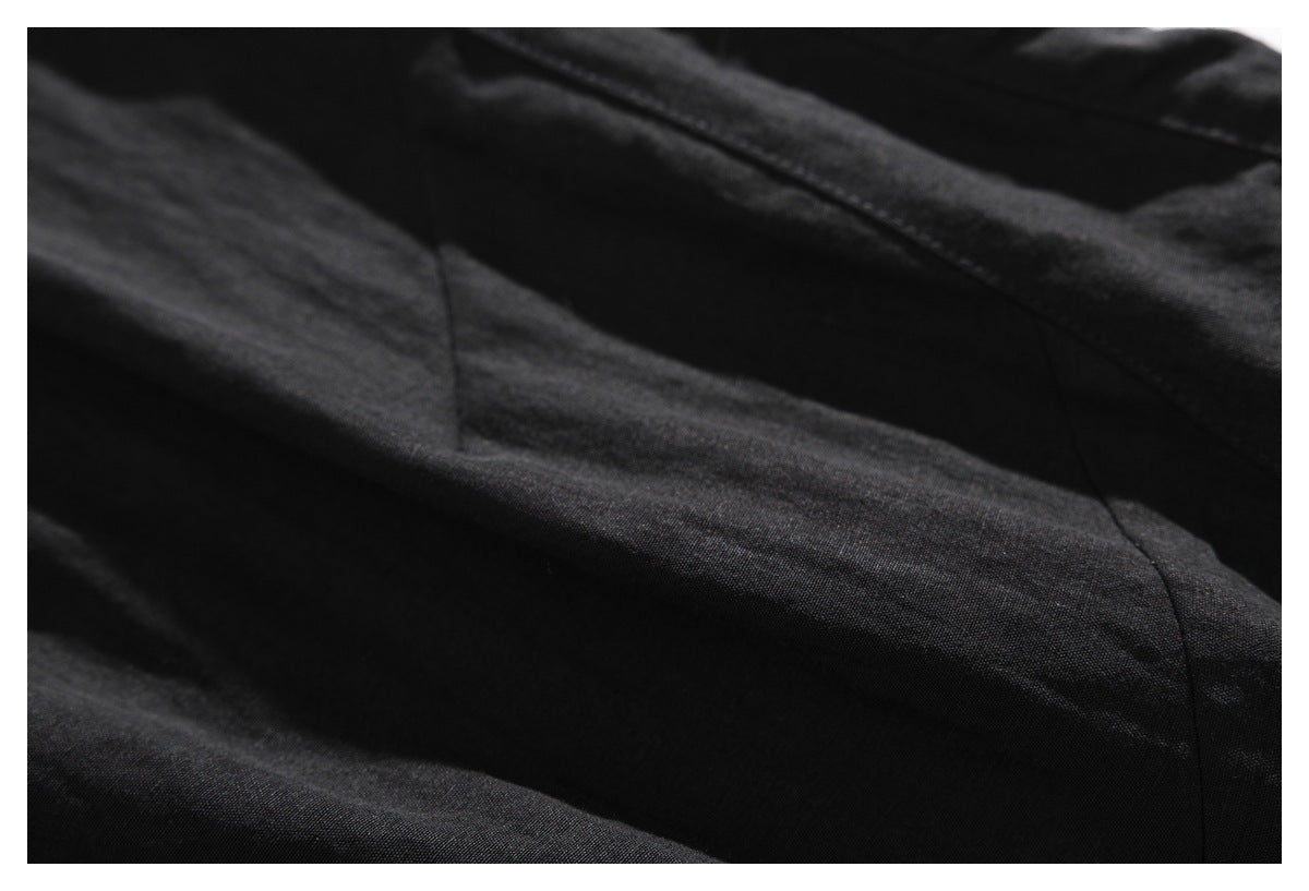 Close-up of black fabric with a curved stitched seam and soft folds.