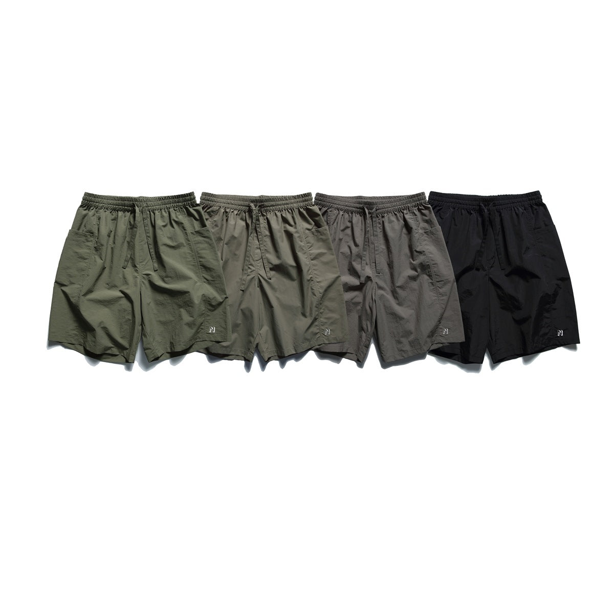 Four pairs of casual shorts shown from the front in olive, gray-green, gray, and black.