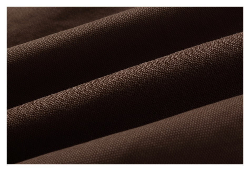 Close-up of dark brown fabric with a small textured weave and soft folds.