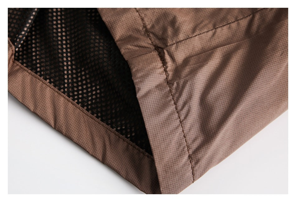 Interior close-up of brown shorts showing black mesh lining and stitched seams.