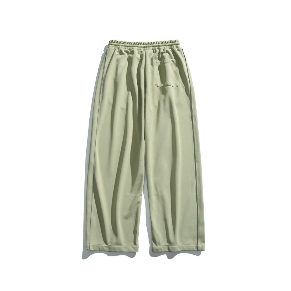 Pale sage wide-leg pants with an elastic waistband and a small patch pocket, shown flat against white.