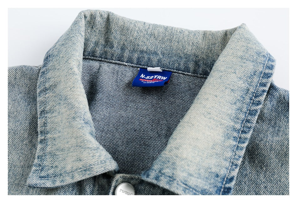 Close-up of the light-wash denim jacket collar, stitching and sewn-in neck label.