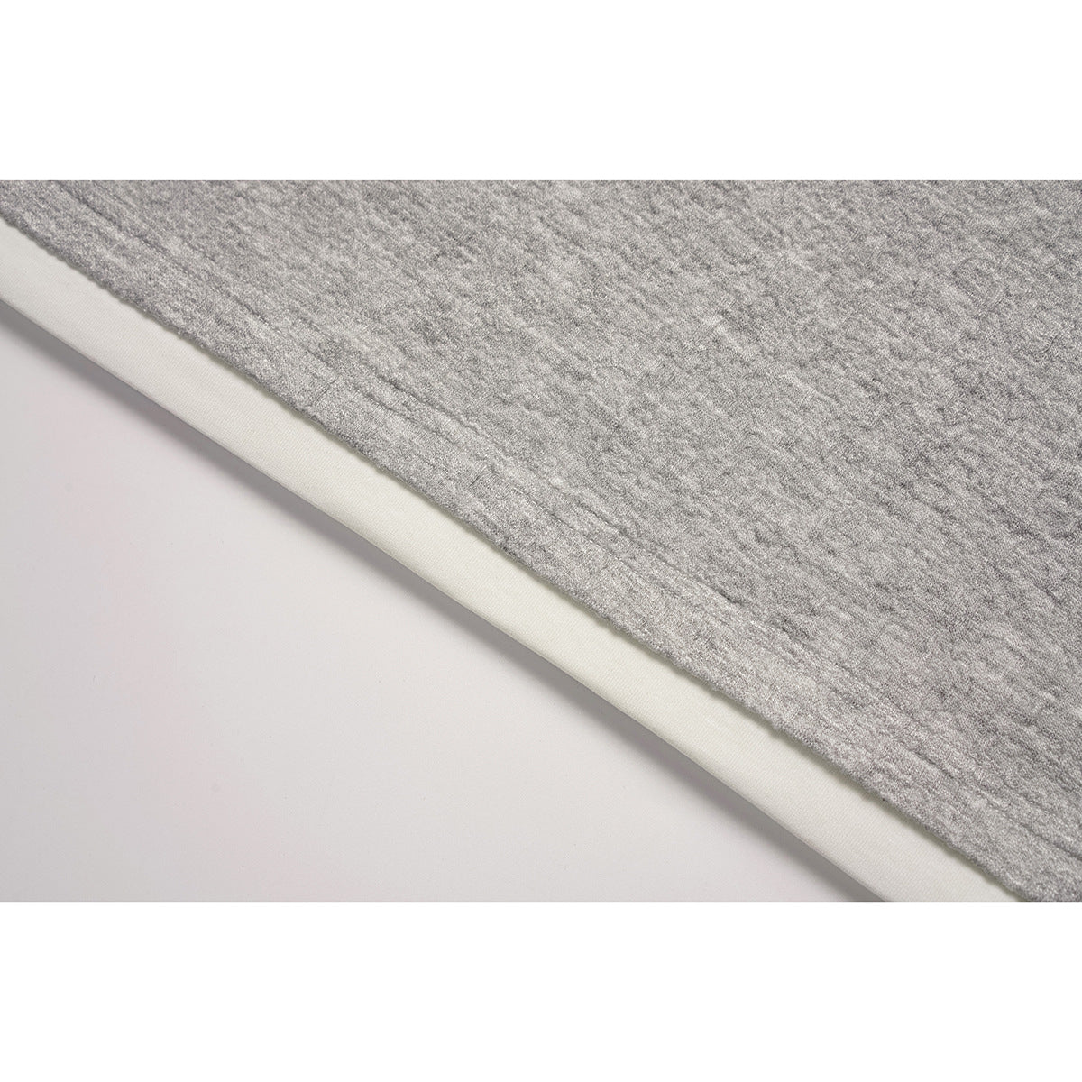 Close-up of the gray sweatshirt hem with a white layer showing underneath.