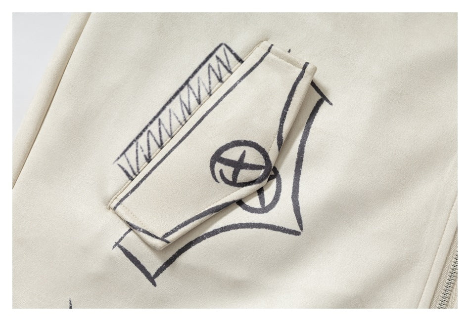 Close-up of a cream jacket pocket flap with dark sketch-style graphics and a circular symbol.