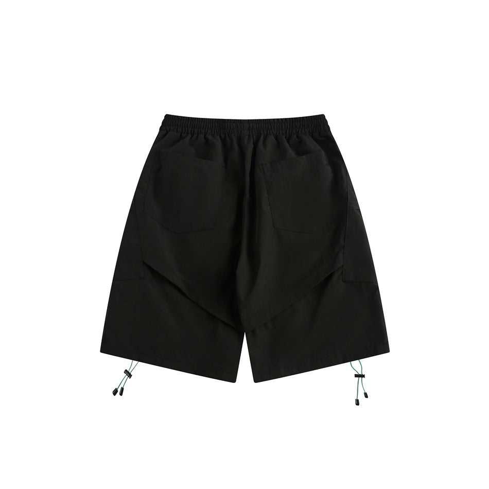 Back view of black shorts with an elastic waist, two patch pockets, and teal cords at the hems.