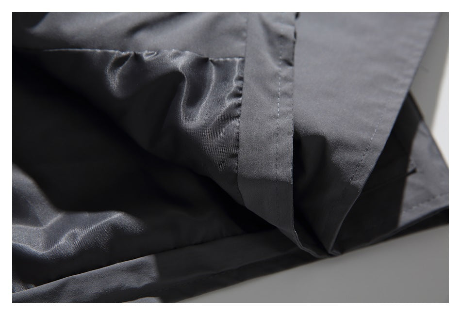 Close-up of the charcoal-gray jacket's interior lining, seams, and folded fabric edge.