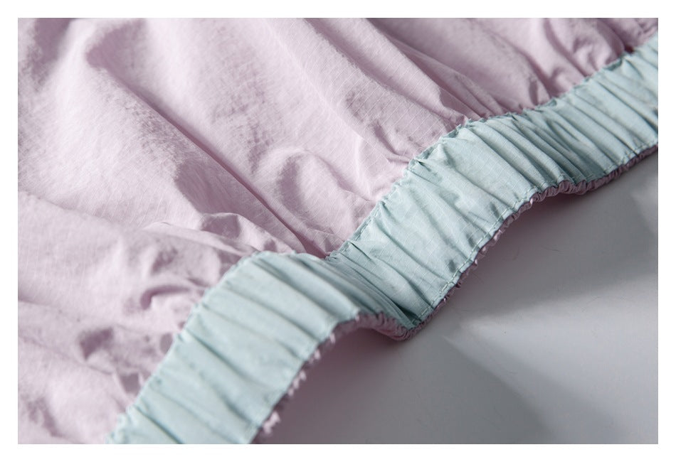 Close-up of pale lavender jacket fabric and a gathered light blue elastic edge.