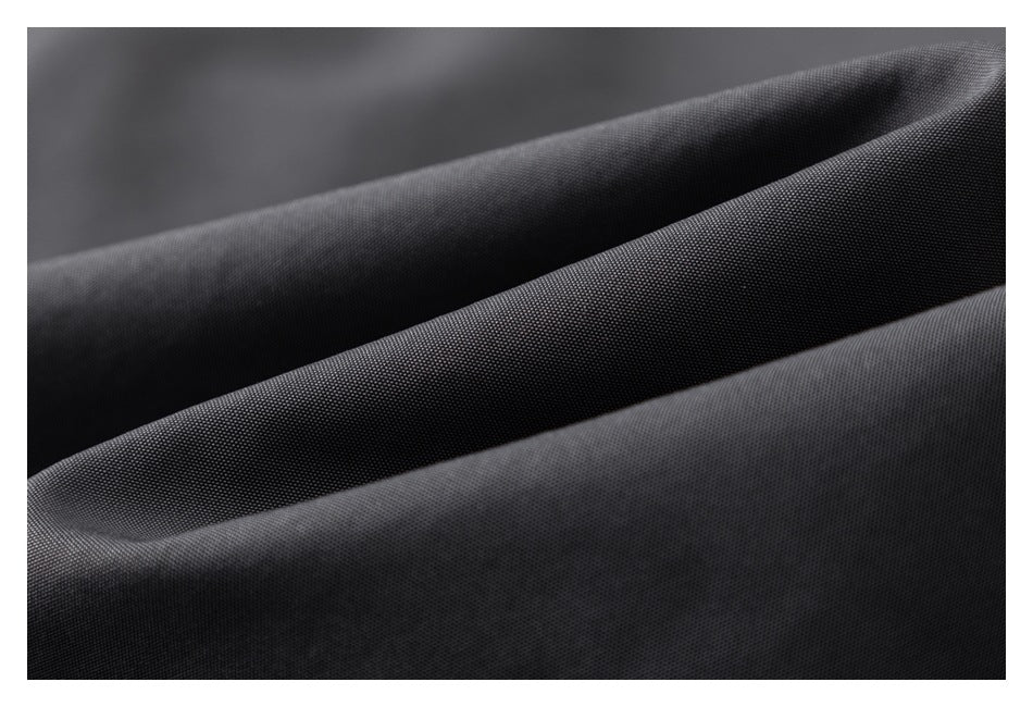 Close-up of charcoal fabric arranged in soft folds, showing its fine textured surface.