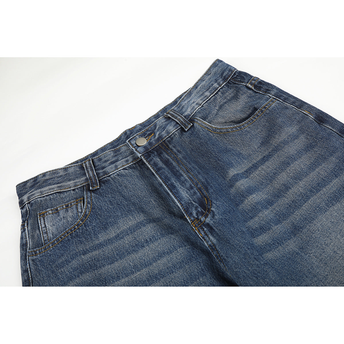 Close-up of the front waist of faded blue jeans, showing the button, belt loops, fly, and front pocket.