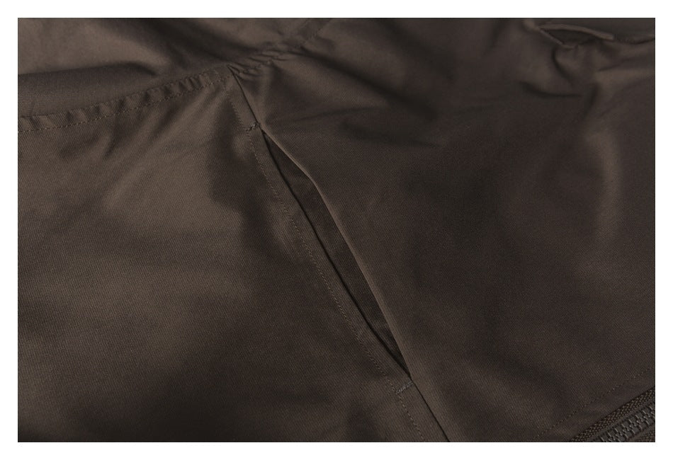 Close-up of a dark brown jacket seam and pocket opening with visible stitching.