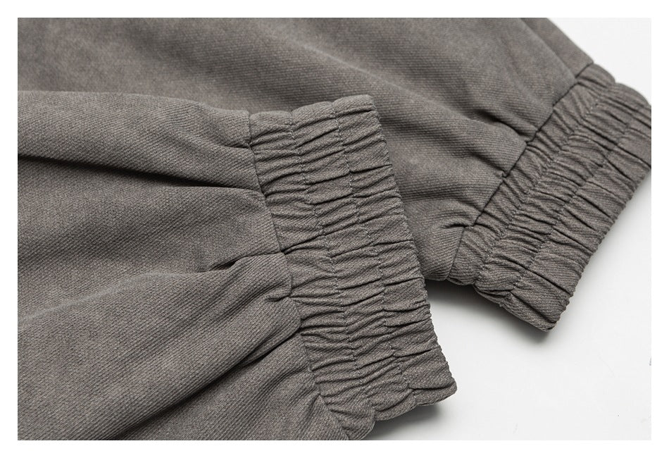 Close-up of gathered elastic cuffs on charcoal gray fabric.