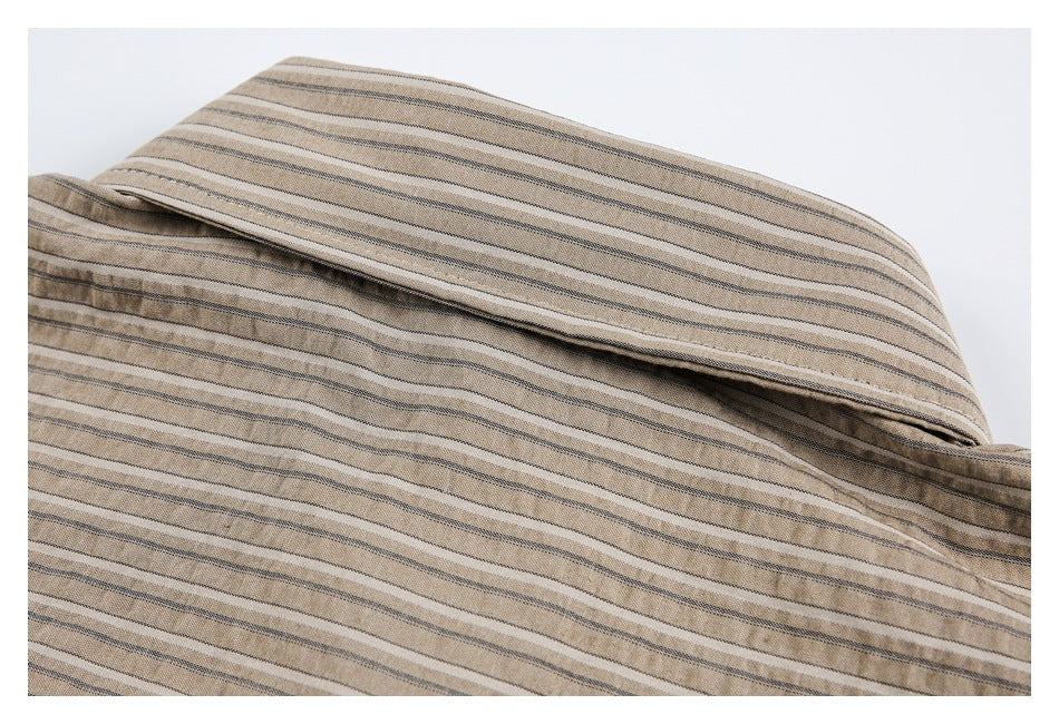 Close-up of the folded collar and upper back of a tan shirt with narrow dark stripes.