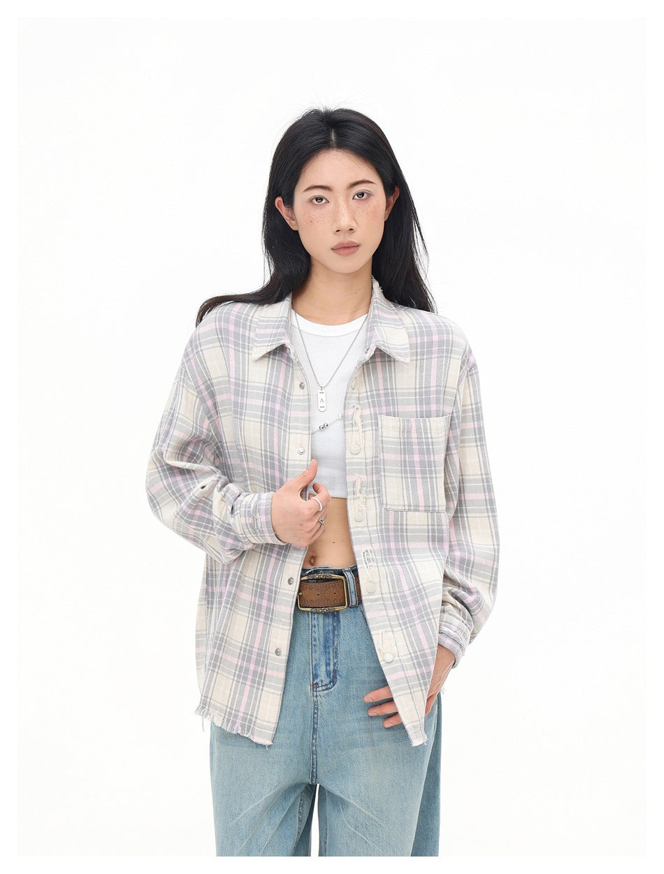 Model wearing an open cream, gray and pale pink plaid shirt with a chest pocket and frayed hem.