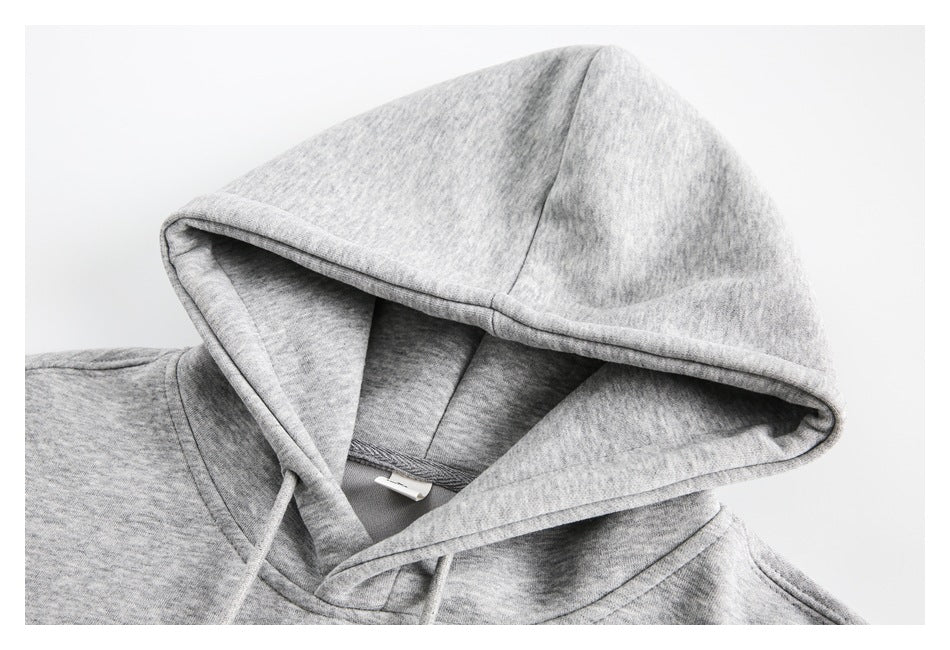 Close-up of the heather-gray hoodie’s lined hood, drawstrings, and shoulder seam.