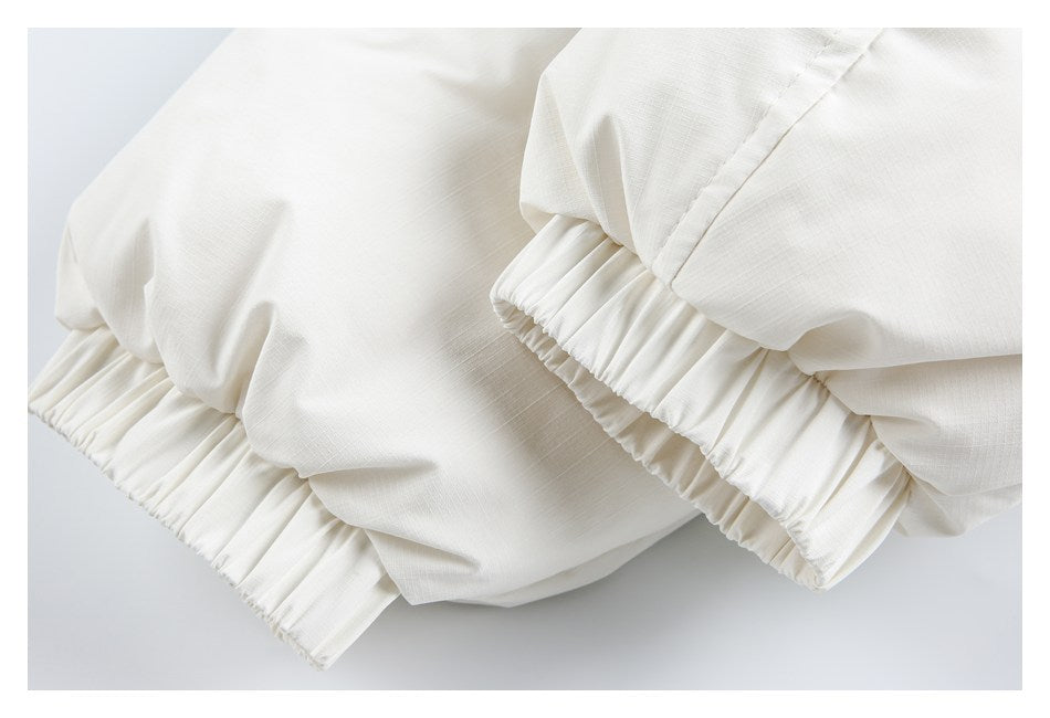 Close-up of gathered elastic cuffs on a white garment.