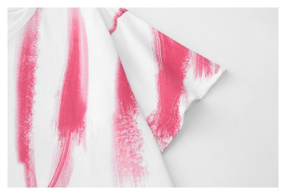 Close-up of the white T-shirt’s short sleeve and pink brushstroke print.