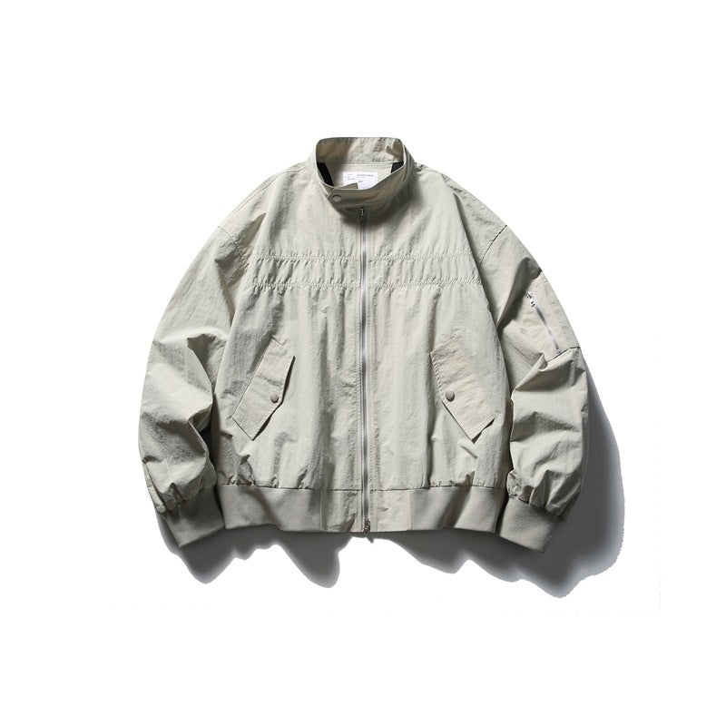 Beige-gray stand-collar zip jacket flat lay with chest gathering, flap pockets, sleeve zip pocket and ribbed hem