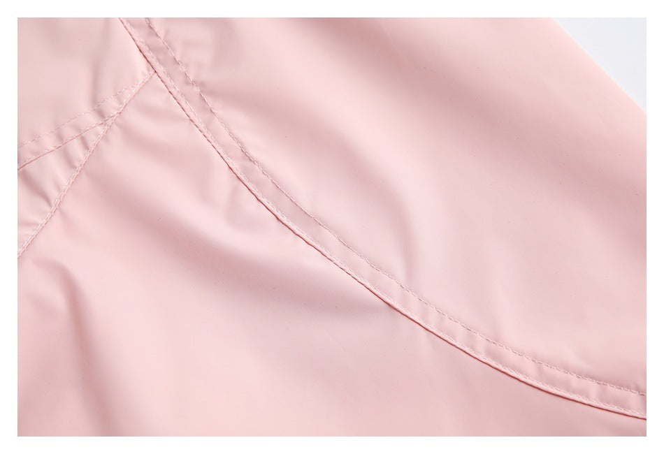 Close-up of curved stitched seams and a panel on pale pink garment fabric.