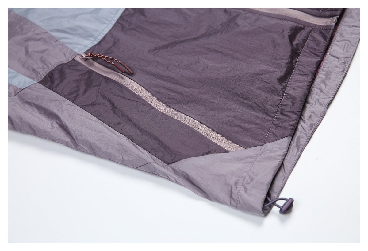 Close-up of the jacket's diagonal zip pocket and adjustable toggle at the hem.