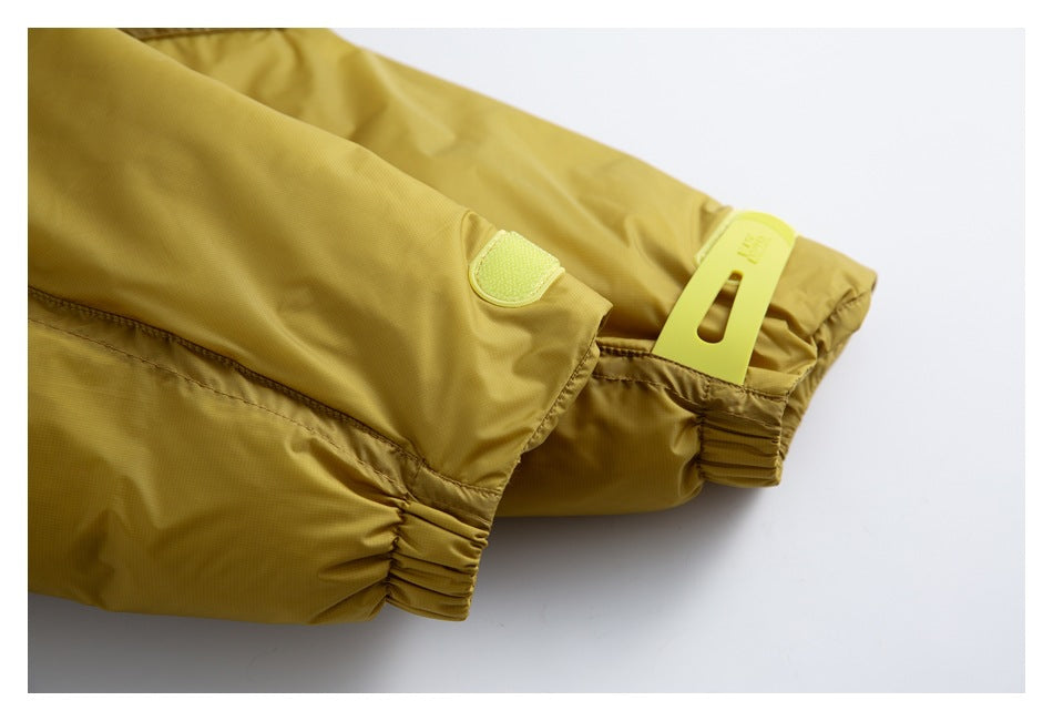 Close-up of the mustard-yellow jacket sleeve cuff with elastic gathering and a bright yellow fastening tab.