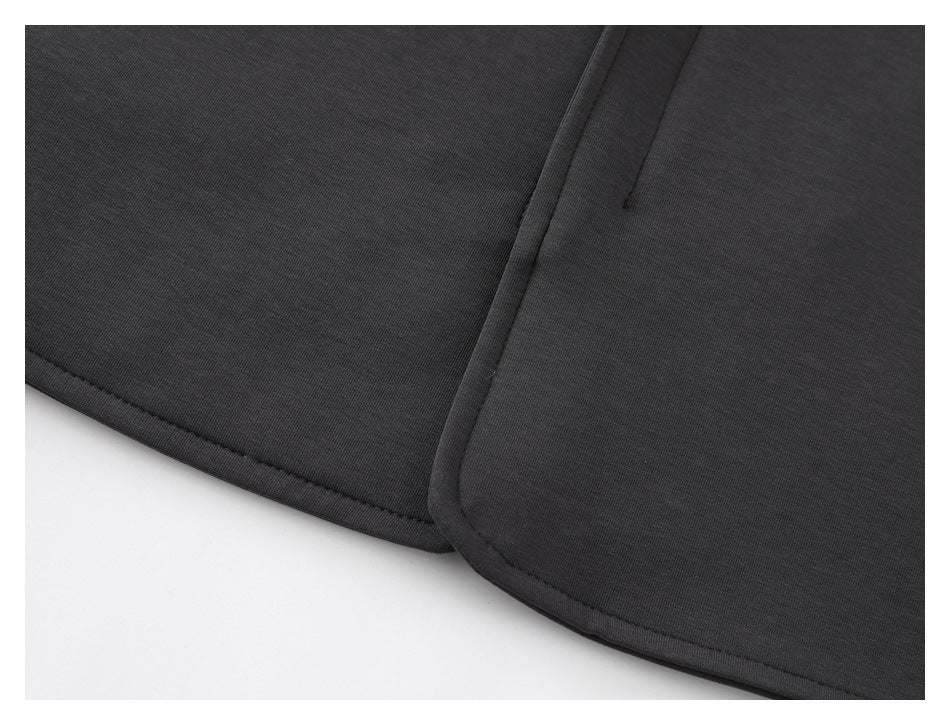 Close-up of charcoal garment panels with stitched hems and a narrow seam opening.