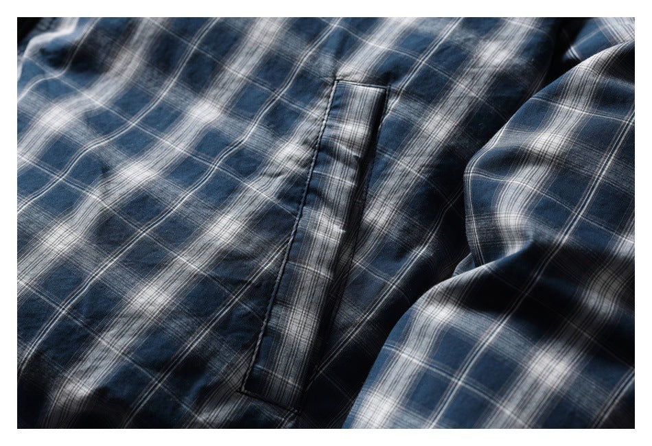 Close-up of a blue-gray plaid jacket showing a narrow vertical pocket opening.