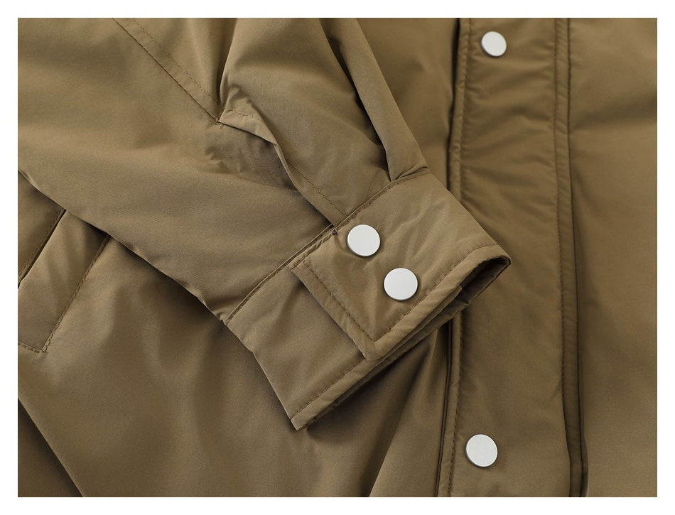 Close-up of a khaki jacket sleeve cuff with two white snaps and the front placket.