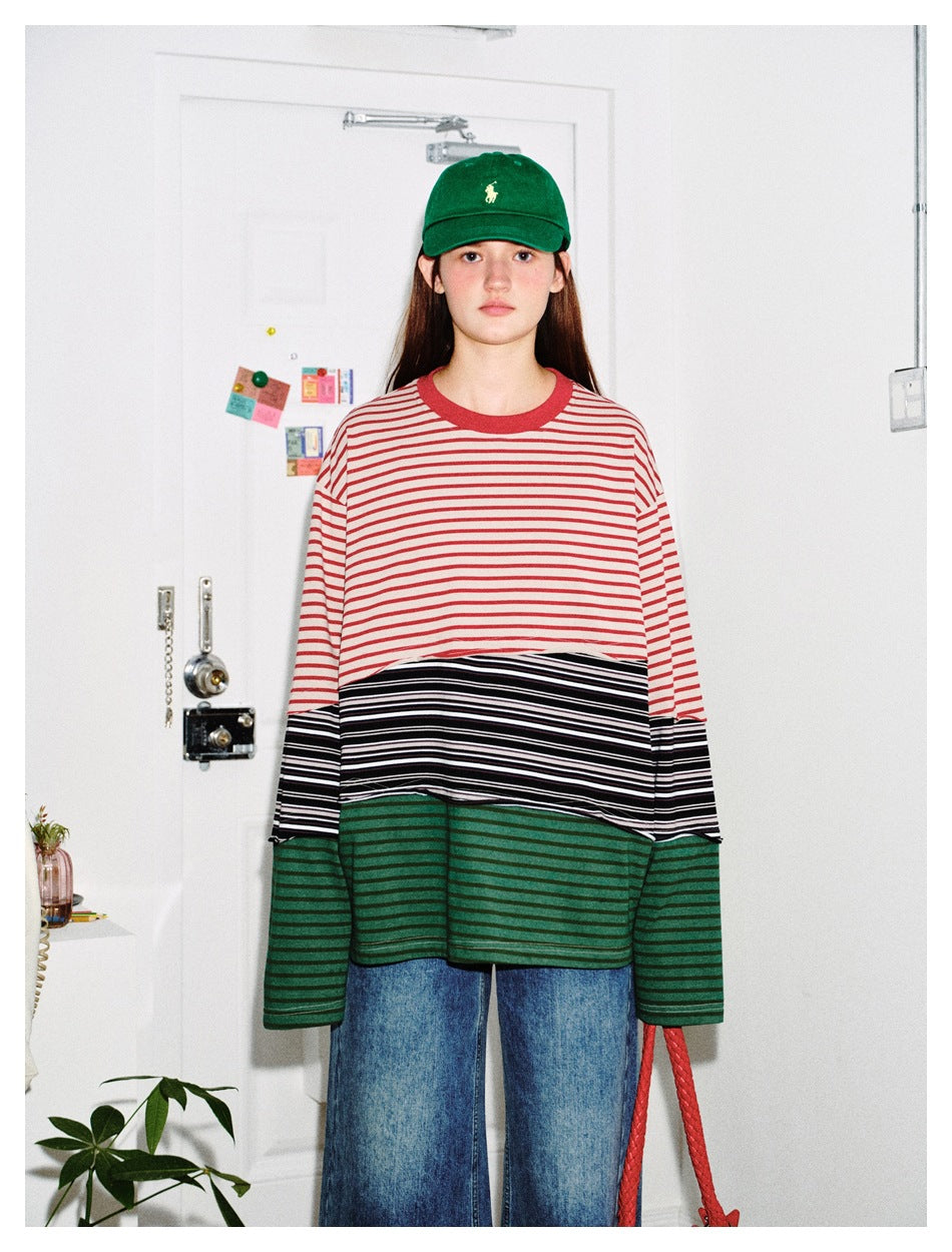 Model wearing an oversized color-block long-sleeve shirt with red and cream, black and white, and green stripes.