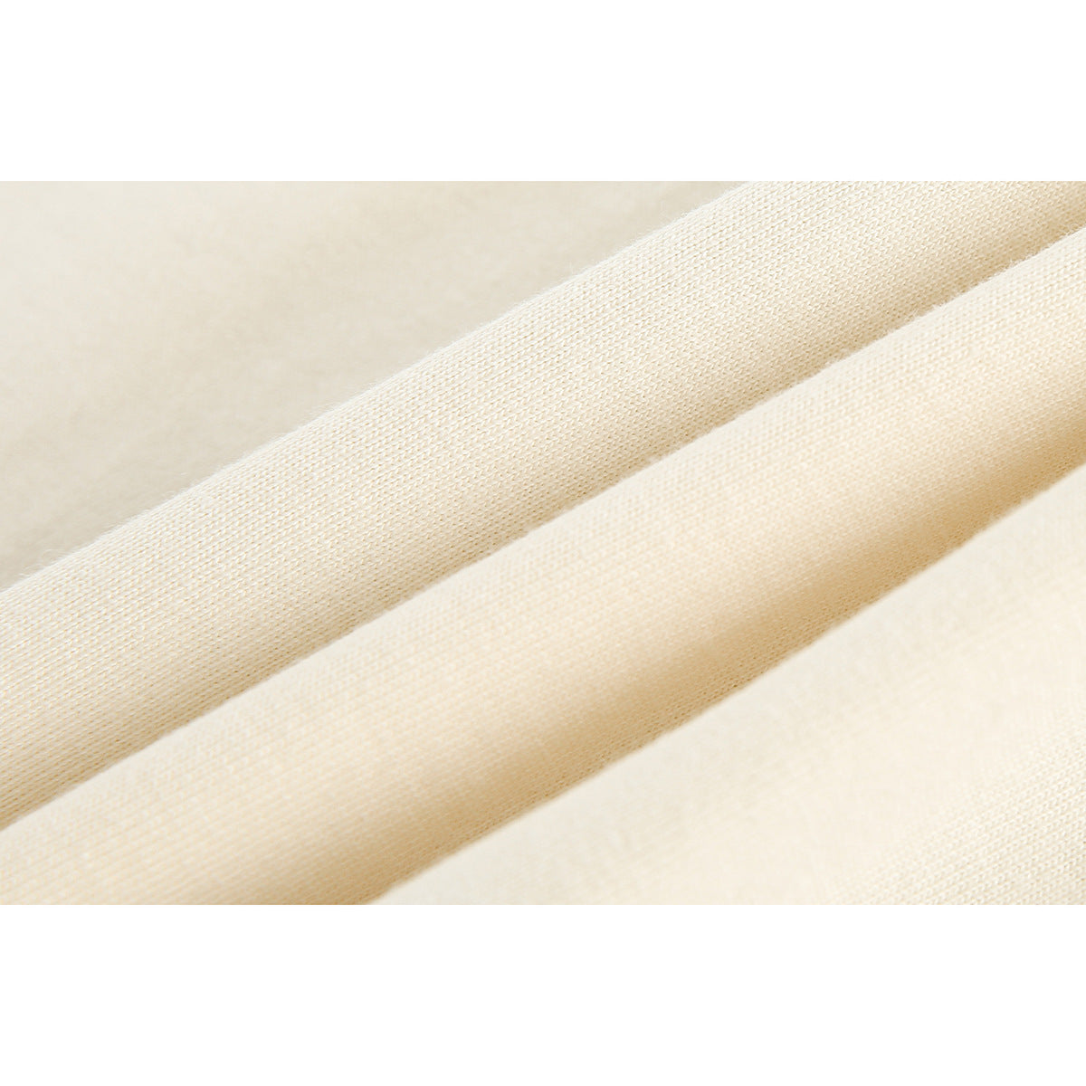 Extreme close-up of pale cream knit fabric arranged in diagonal folds.