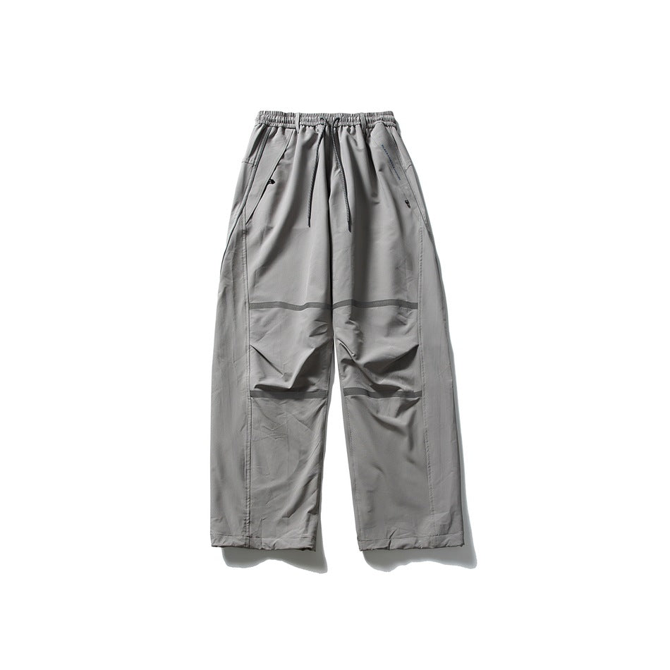 Gray wide-leg pants shown from the front, with an elastic drawstring waist, angled pockets and horizontal knee bands.