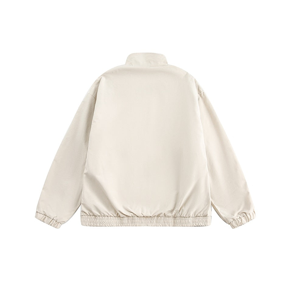 Back view of a plain cream jacket with a stand collar, elasticated cuffs, and gathered hem.