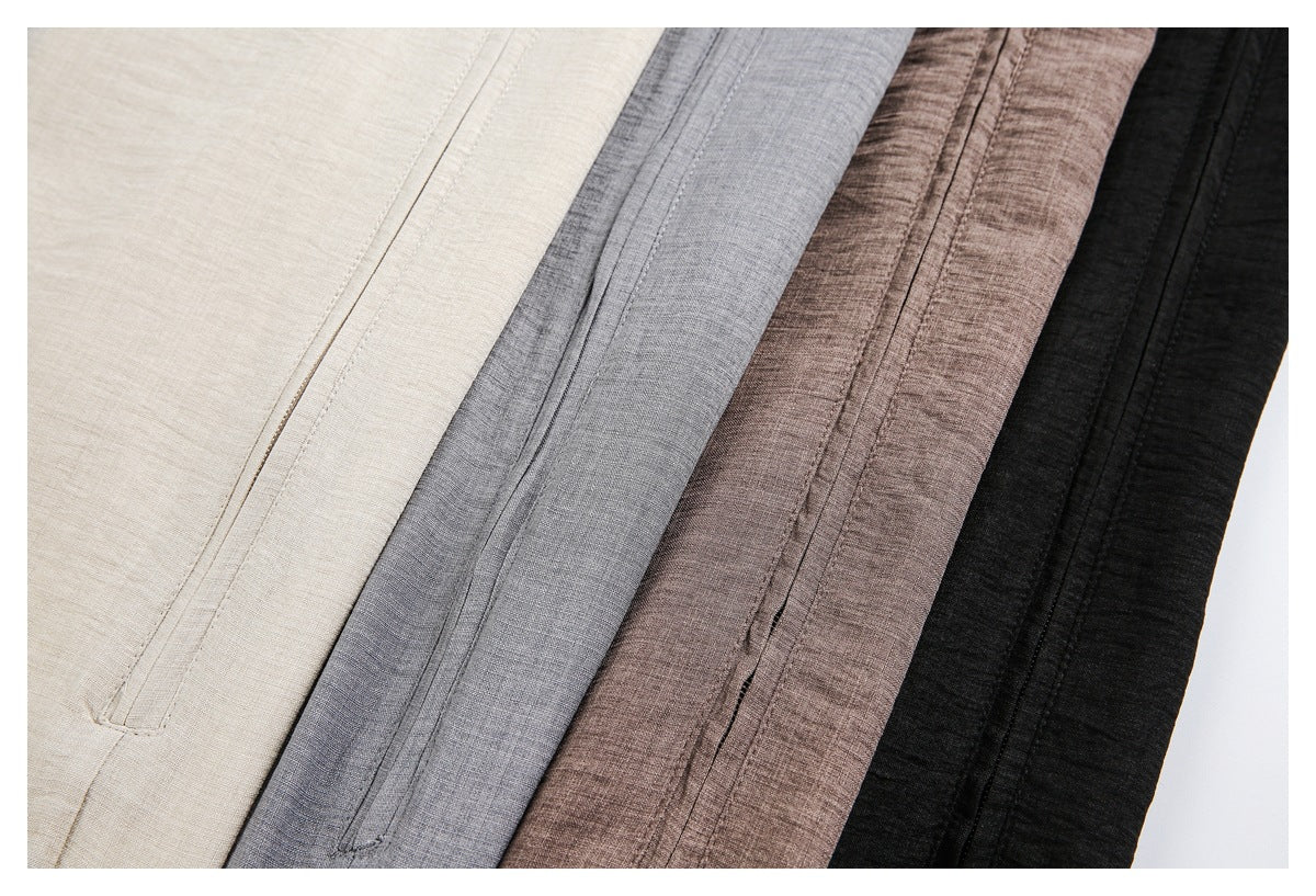 Close-up of stitched pocket openings on overlapping ivory, gray, taupe, and black garment colorways.