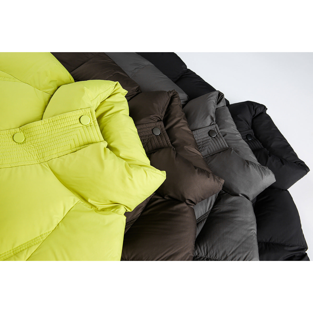 Close-up of padded jacket waist tabs with snap buttons in lime, brown, charcoal, and black.