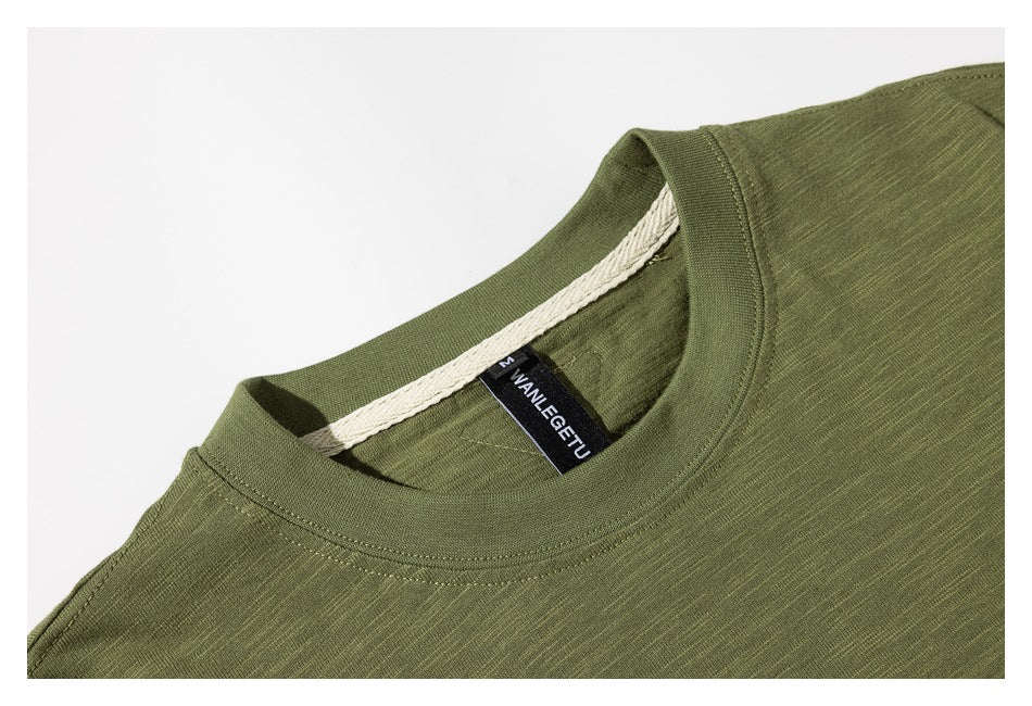 Close-up of an olive green T-shirt neckline with ribbed collar stitching and a black neck label.