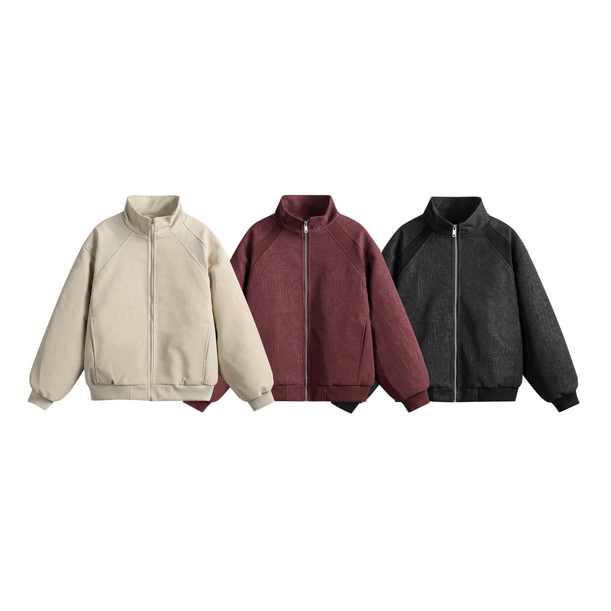 Three front-view zip-up jackets in ivory, burgundy, and black, with stand collars and ribbed trim.