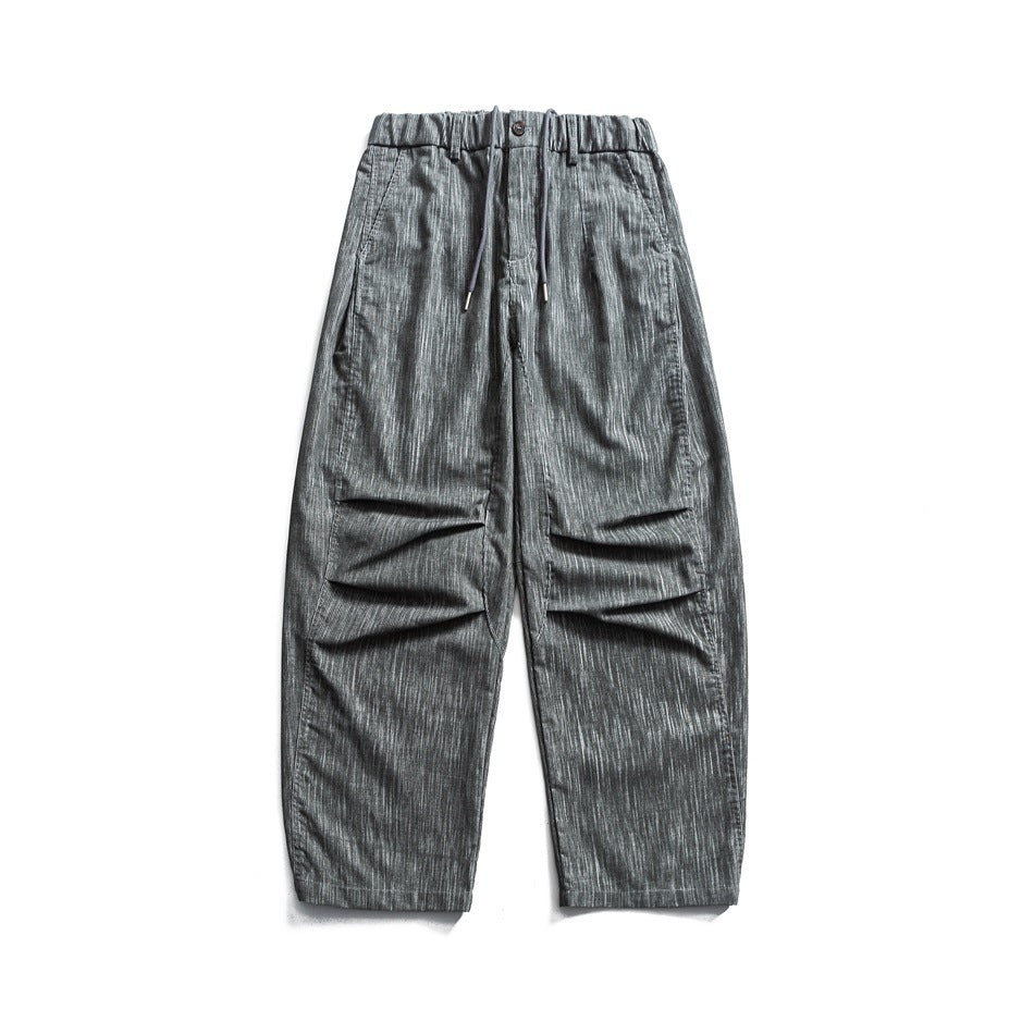 Gray wide-leg drawstring pants with elastic waist, knee pleats and streaky textured fabric, flat lay front view