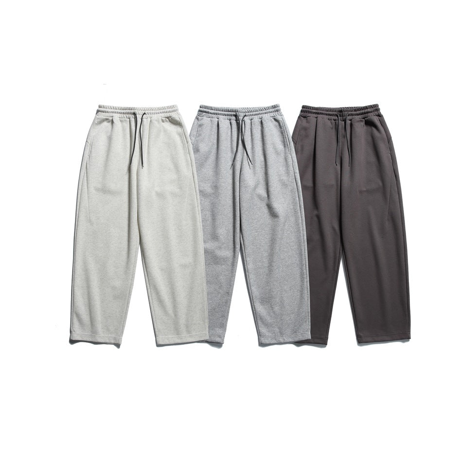 Three pairs of wide-leg drawstring sweatpants shown from the front in light gray, heather gray, and dark charcoal.