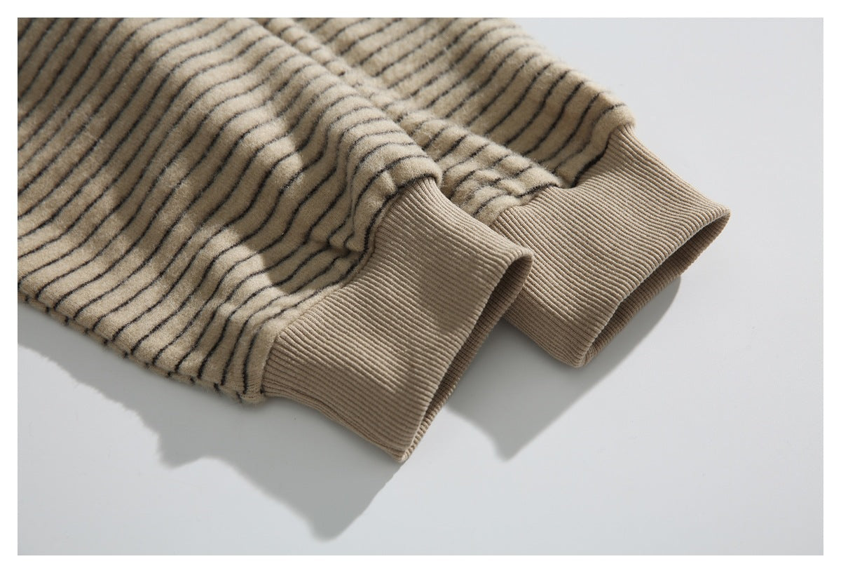 Close-up of two ribbed cuffs on a beige jacket with thin dark stripes.