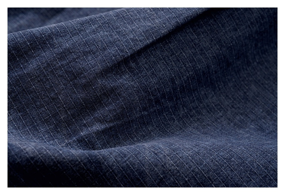 Close-up of dark blue fabric with a subtle fine pinstripe pattern.