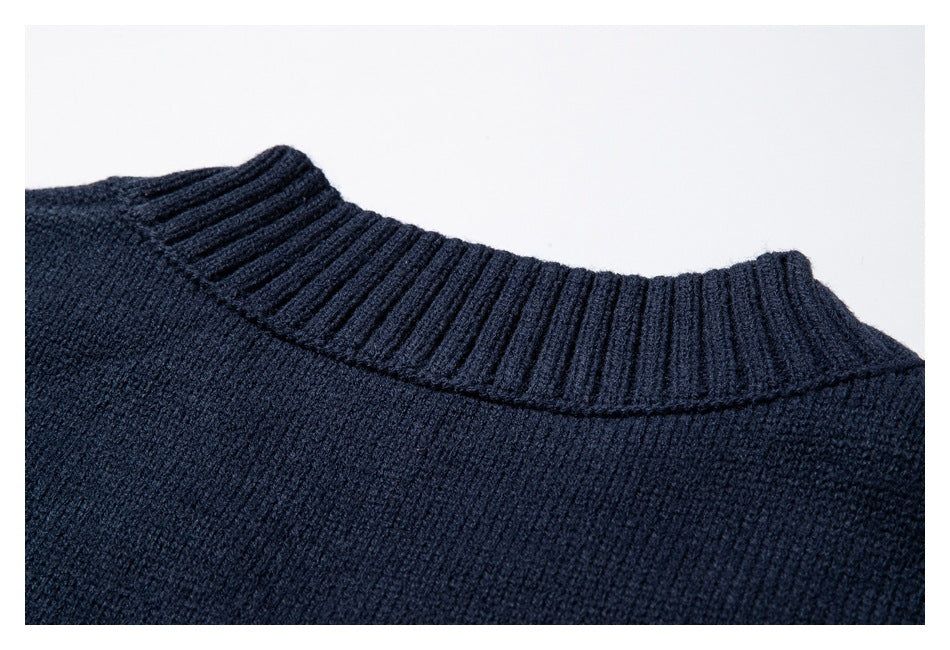 Close-up of the dark navy sweater's ribbed crew neckline from the back.