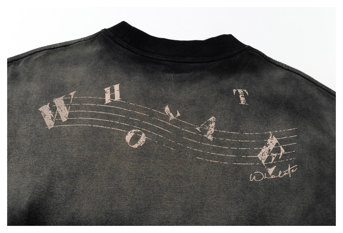 Back graphic on a dark garment with scattered pale letters and curved musical staff lines.
