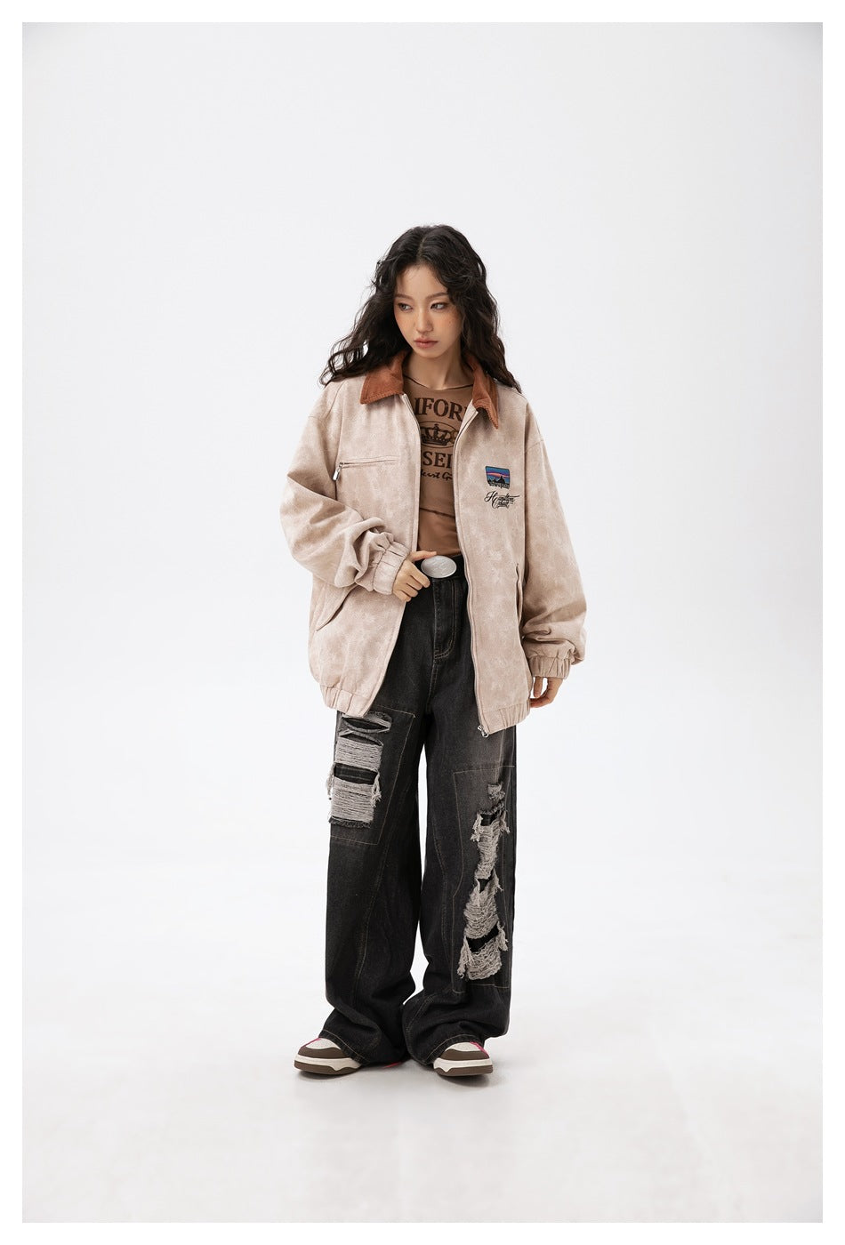 Model wearing an open beige-khaki oversized jacket with brown collar, angled three-quarter view looking to the side