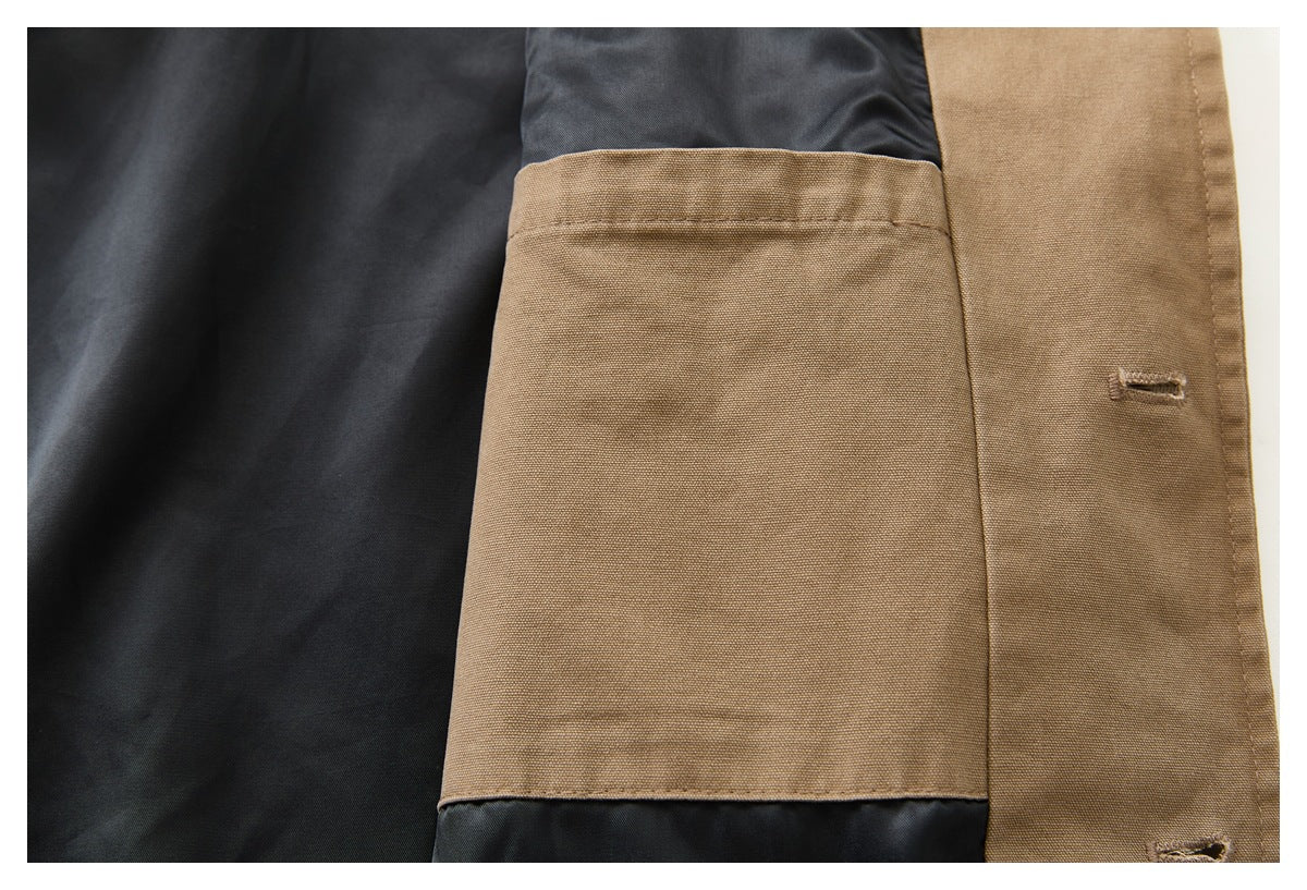 Close-up of a tan fabric pocket panel and buttonholes against dark garment lining.
