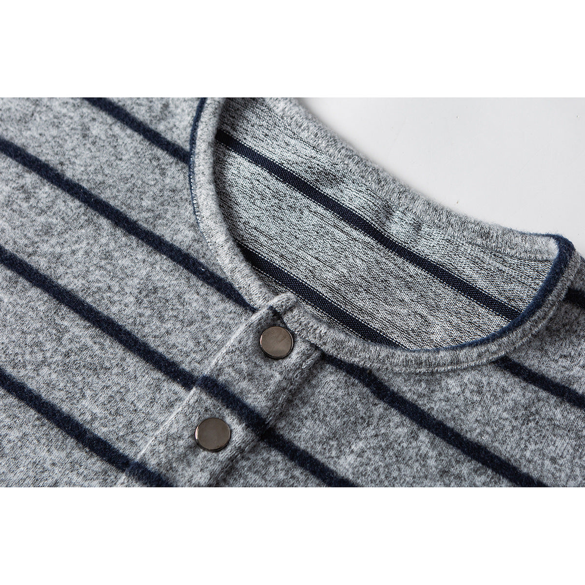 Close-up of a gray striped shirt's rounded neckline and four-button placket.