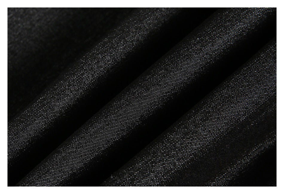 Macro view of dark black woven fabric draped into folds.