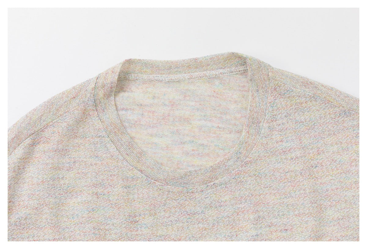 Close-up of the light oatmeal top's crew neckline, shoulder seams, and multicolor-flecked fabric.
