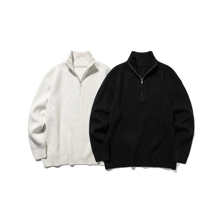 Ivory and black quarter-zip knit sweaters shown from the front with ribbed high collars and cuffs.