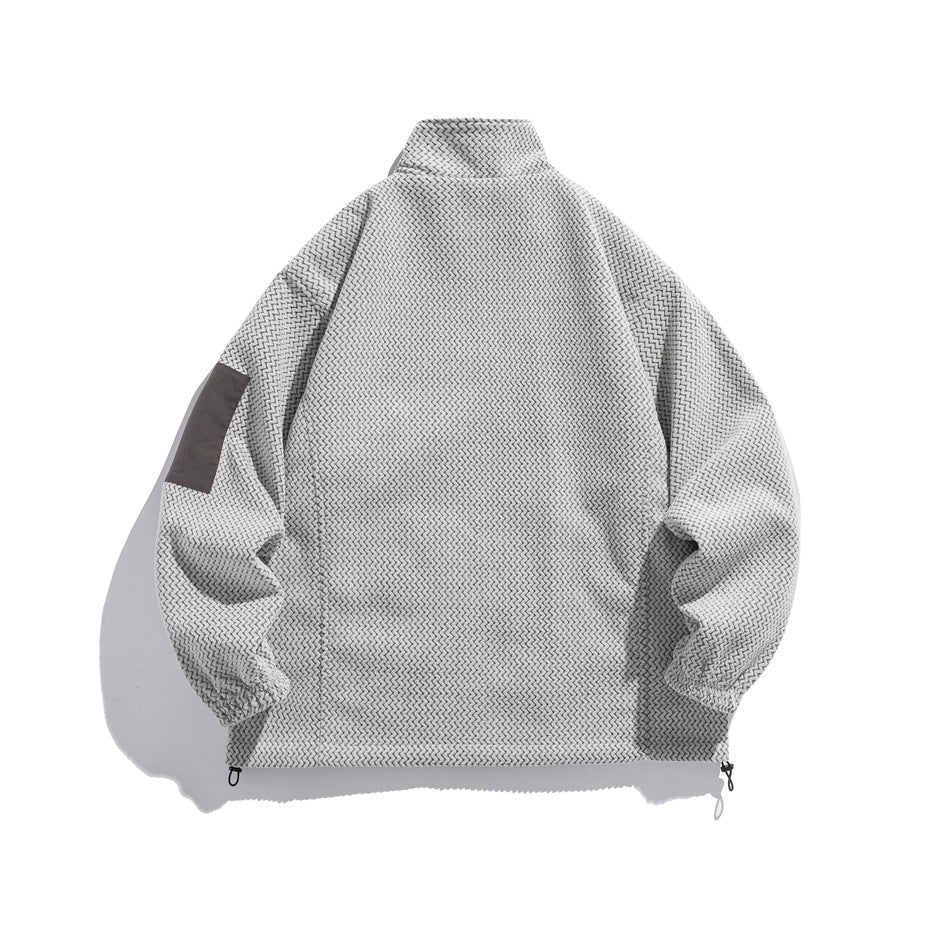 Back view of a light gray patterned jacket with a raised collar, dark sleeve patch and adjustable hem.