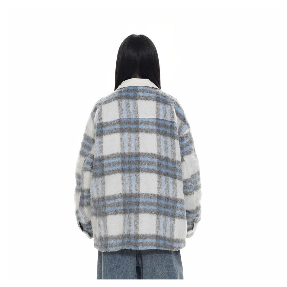 Back view of a model wearing a gray, white and blue plaid jacket with blue jeans.